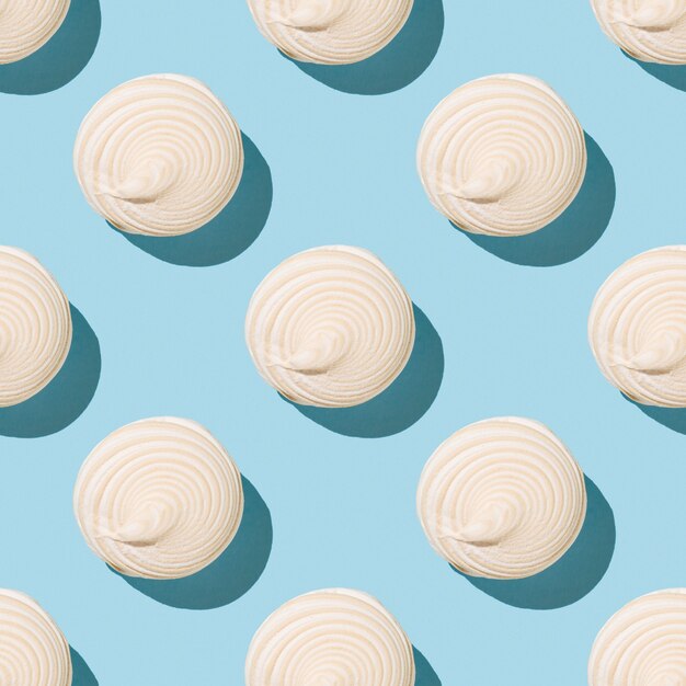 Seamless pattern of beige meringue on a blue surface