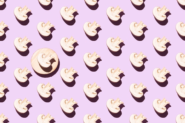 Seamless pattern of cut champignons on a purple background