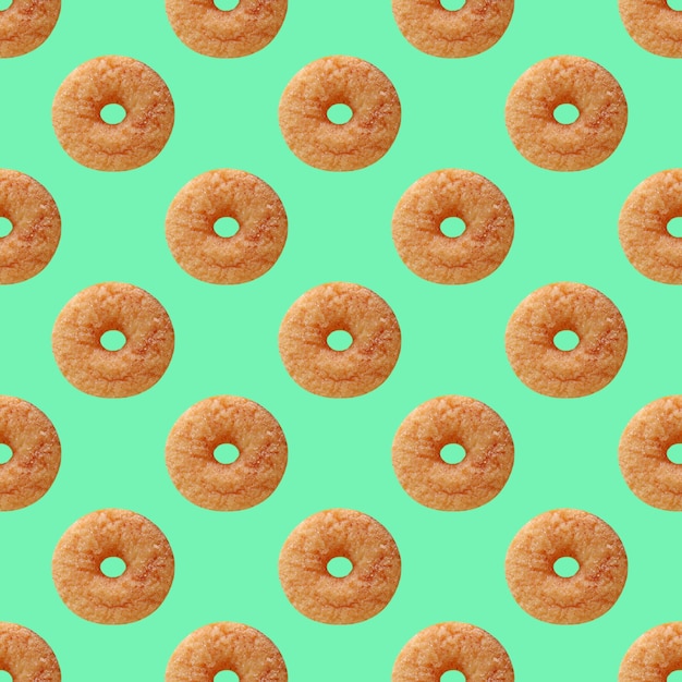 Seamless Pattern of Delectable Cinnamon Doughnut on Mint Green Colored Background