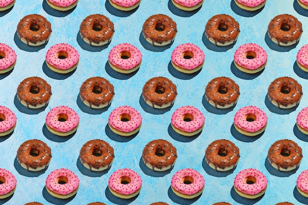 파란색 바탕에 분홍색과 갈색 유약으로 도넛의 완벽 한 패턴입니다.