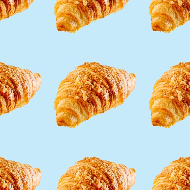 Seamless pattern made from Fresh croissant with cheese isolated on blue background