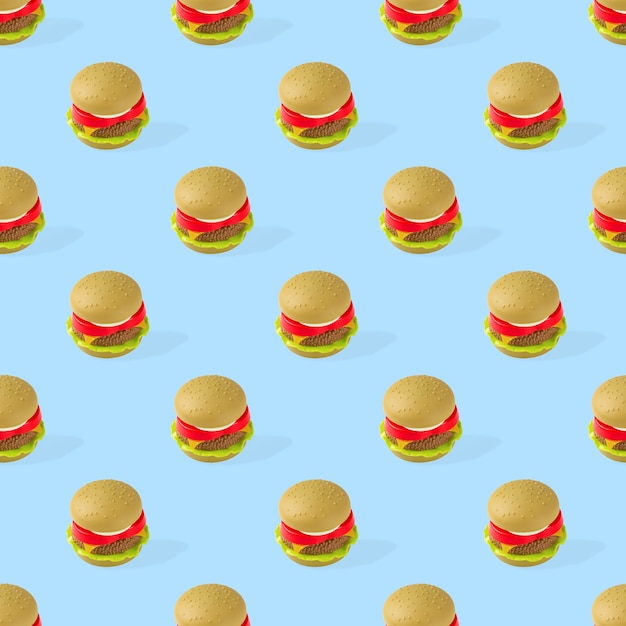 seamless pattern of plastic childrens toy burger with salad, tomato, meat on blue background.