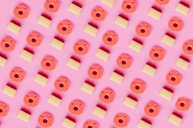 Seamless pattern of yellow sponges for washing dishes on pink background Minimal concept