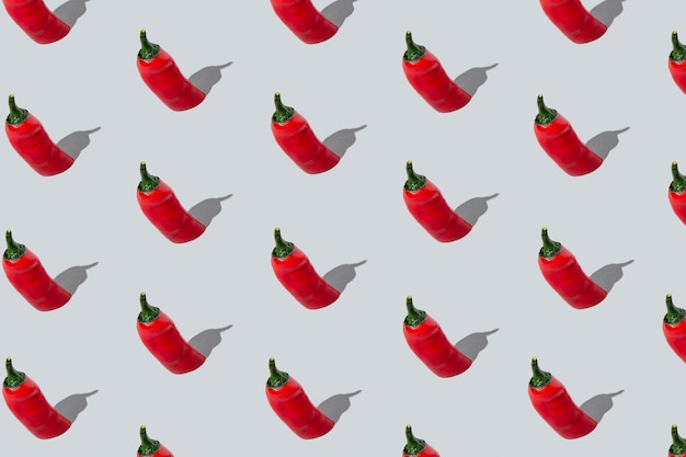 Seamless red chili peppers pattern on light grey background. Isometric layout.