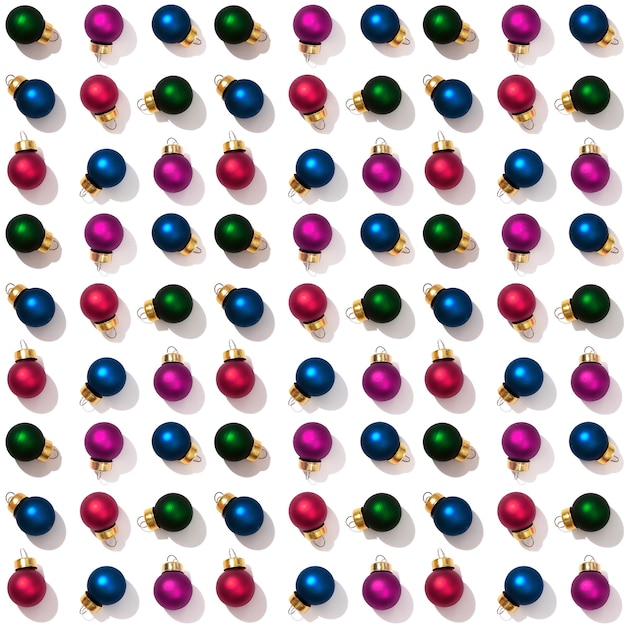 Seamless regular creative pattern with bright little colorful Christmas balls isolated on white