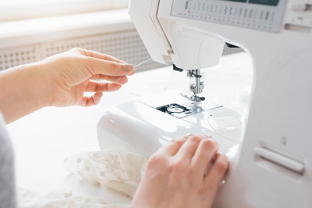 Seamstress adjusts the sewing machine to work