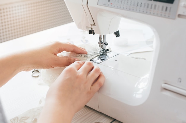 Seamstress adjusts the sewing machine to work