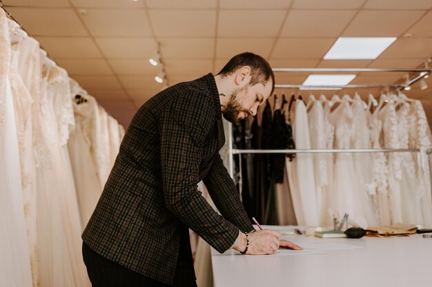 Seamstress creates a sketch in the working notebook designer draws the clothes and bags