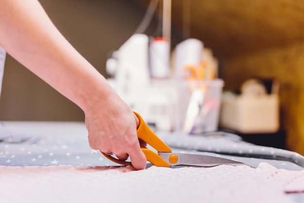 洋服縫製ワークショップで布地を切る裁縫師