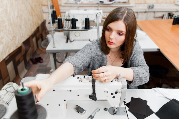 Seamstress fixing thread on sewing machine.