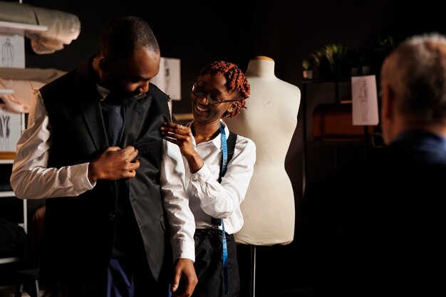 Photo seamstress helping client try on attire