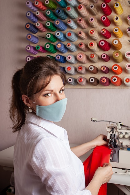 La sarta con la maschera si sovrappone al bordo del tessuto del futuro vestito rosso