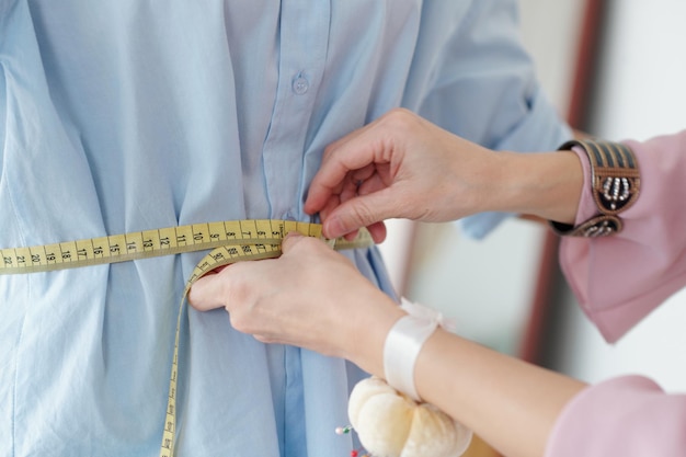 Photo seamstress measuring waist