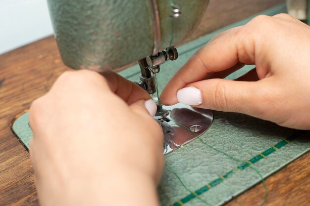 Seamstress puts a thread on a needle in a sewing machine