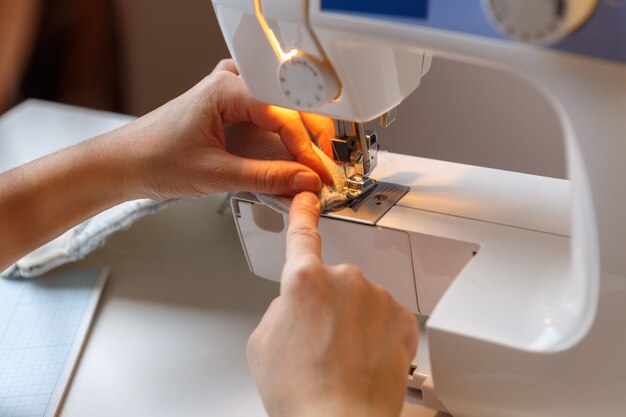 Seamstress sews fabric on machine