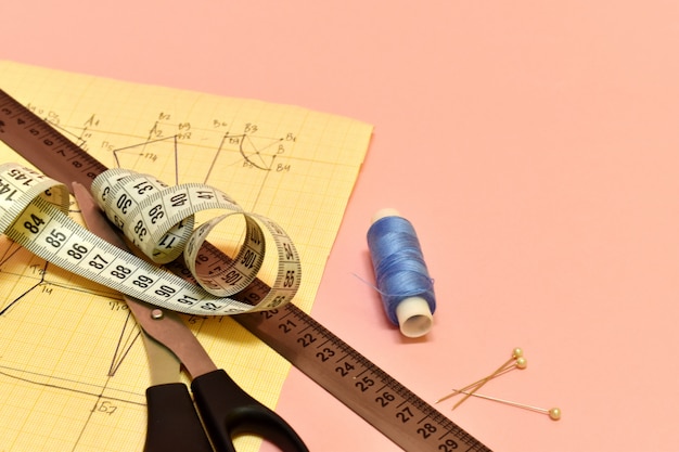 Photo seamstress tools. threads, scissors, pattern and ruler for sewing.