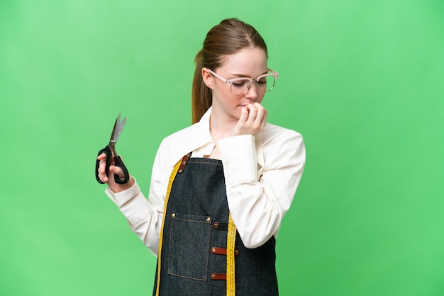 Seamstress woman over isolated chroma key background having doubts
