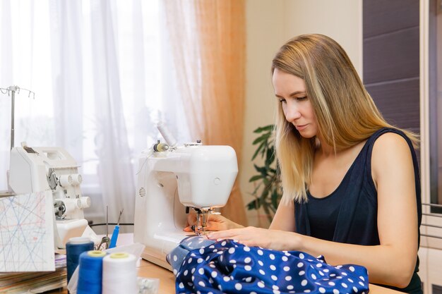 Seamstress woman sewing at home