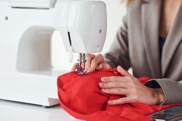 Seamstress working in the office Young woman in formal clothes is indoors Conception of style