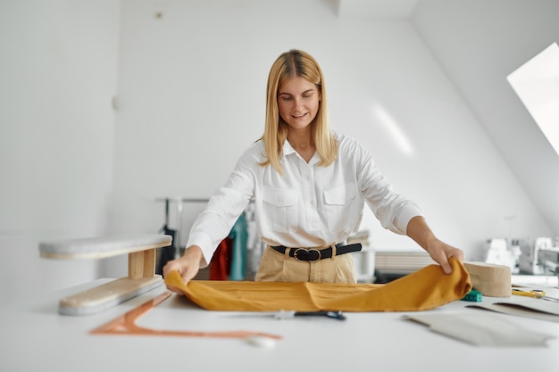 La sarta lavora con il modello di stoffa in officina. occupazione sartoriale e cucito professionale, attività di sartoria artigianale, hobby artigianale