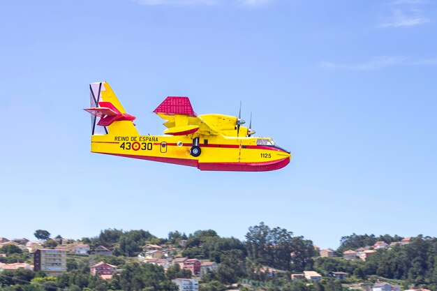 写真 スペイン政府の水上飛行機が沿岸の町を飛んで海に向かう