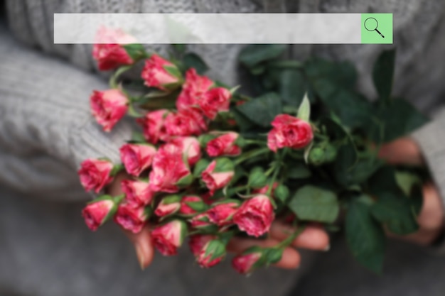 Search bar on the background of blurred bouquet of bush of roses in female hands