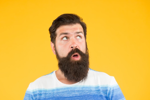 Search for inspiration surprised looking guy male barber care get style in barbershop brutal bearded man on yellow background male summer fashion mature hipster has perfect moustache