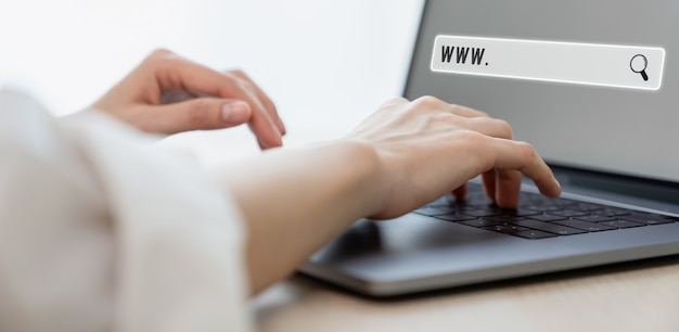 オンラインでブラウザを検索している女性、ノートパソコンとキーボードを使用している女性。