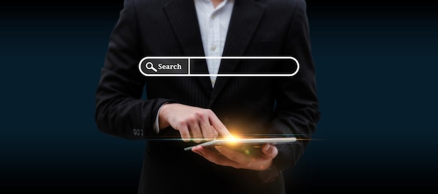 Searching. business man hand touching on digital mobile tablet\
with visual screen search button on dark background, browsing\
information, internet data technology and data search engine\
concept