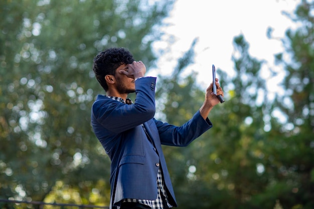 Photo searching for a signal in the telephone in a lonely forest with a blue suit