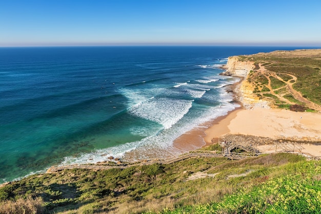 Vista sul mare ericeira portogallo. dai surfisti in acqua.