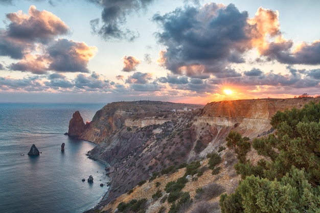 Seascape sopra la spiaggia di jasper durante il tramonto, con la scogliera rocciosa è illuminata dal caldo tramonto. esposizione prolungata. nuvole sfocate di movimento. copia spazio. il concetto di calma silenzio e unità con la natura