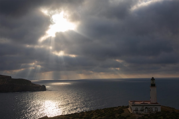 Seascape of the Mediterranean coast with a lighthouse at sunset