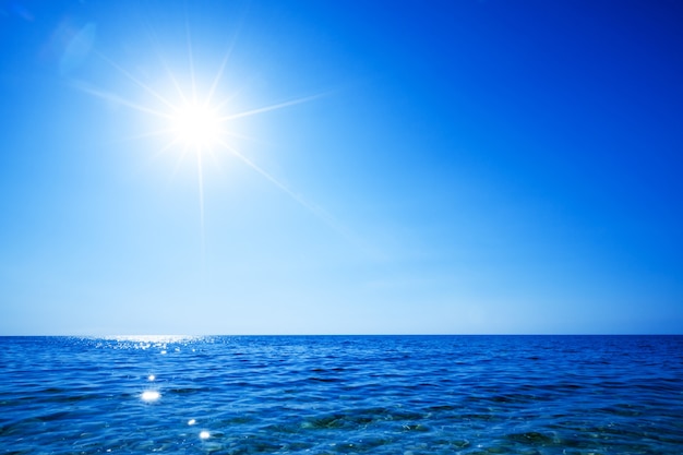 Фото Морской пейзаж все еще морской поверхности, золотое солнце в небе в летний ясный день. неподвижные пейзажи путешествий и мест назначения