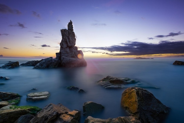 Seascape rock beach in black and white during storms a slow shutter speed was used to see the