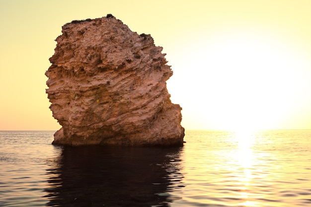 Foto vista sul mare della riva delle acque di mare fermo, del fondo pietroso e delle rocce in mare