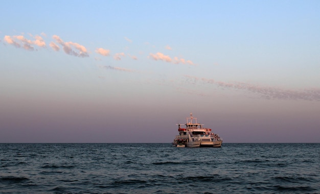 Морской пейзаж солнечный день и голубое облачное небо и лодка на воде