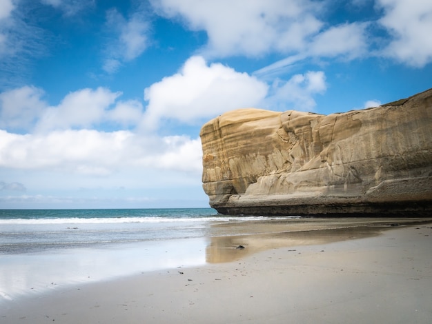 seascape with blue sky and sandstone cliff as a main subject tunnel beach new zealand