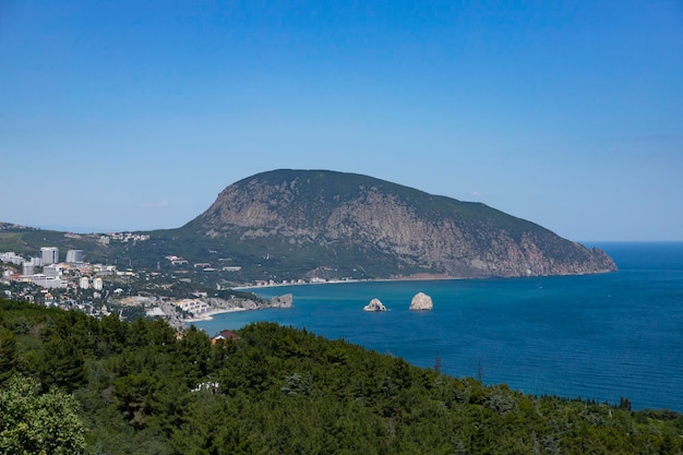 孤独な山と山のふもとにある家々のある海の景色黒海