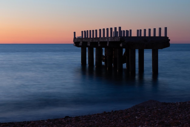 Seascape with ruined pier at night