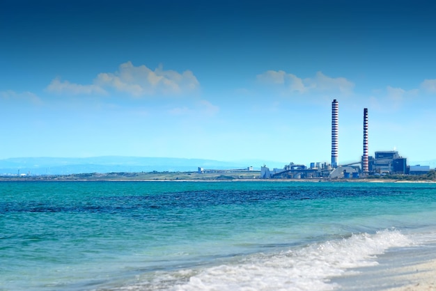 Seascape with smokestack by the sea