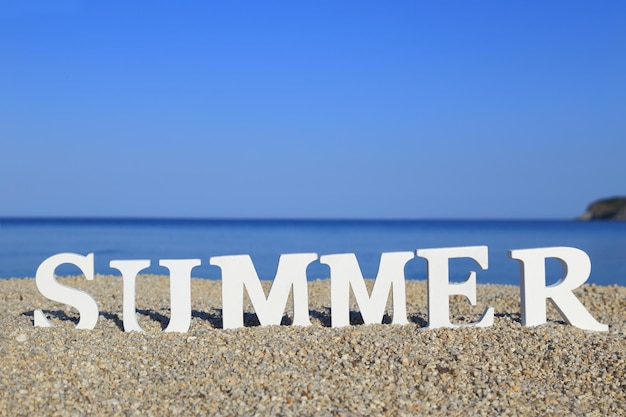 Photo seascape with white word summer on the sand