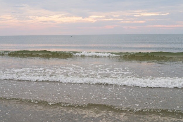 Foto mare spiaggia onda e costa, cielo azzurro con nuvole e luce solare