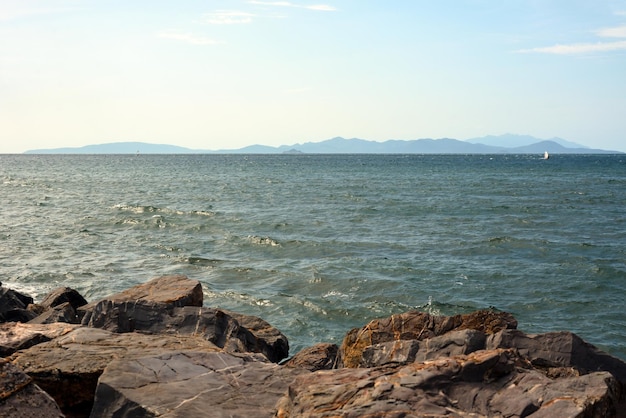 Seashore in the foreground A mountain range can be seen in the distance on the horizon