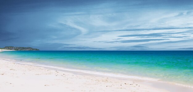 Seaside on a cloudy day White sandy beach Clear blue water 3d illustration