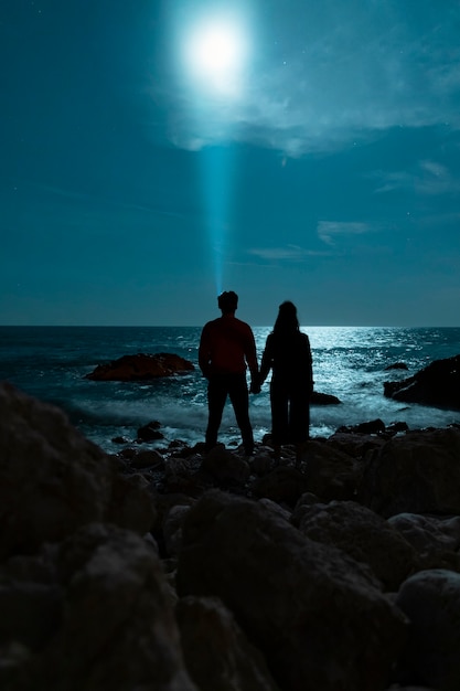 Seaside night walk and couple holding hands