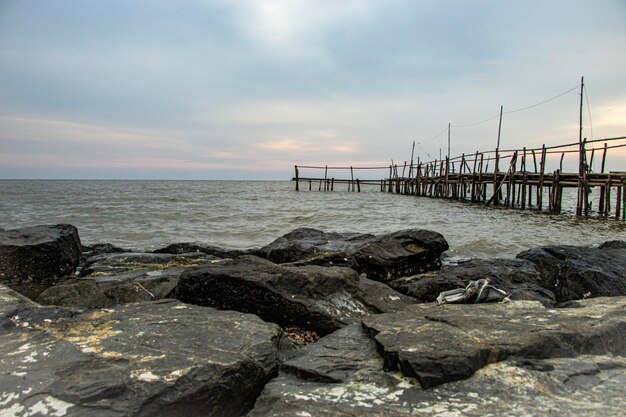 写真 海辺の石のテラスと木製の橋