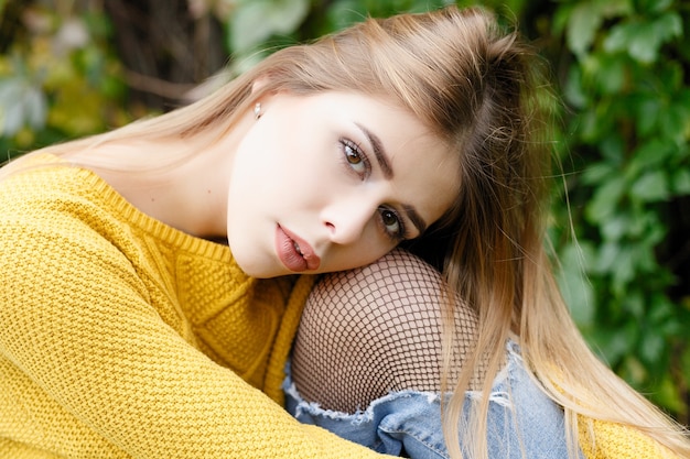 Season and people concept - beautiful happy young woman having fun with leaves in autumn park