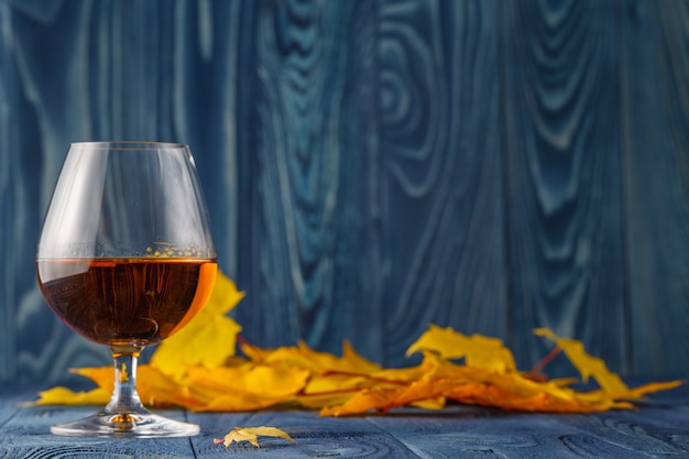 Seasonal alcohol drinking on blue table with leaves