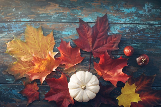 Seasonal composition with pumpkin and autumn leaves on rustic wooden table halloween or thanksgiving decoration background top view